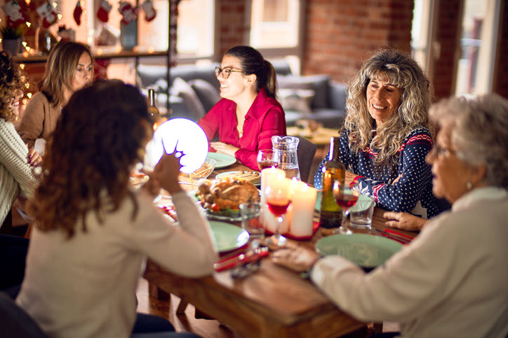 Gruppe isst gemeinsam an weihnachtlich gedecktem Tisch